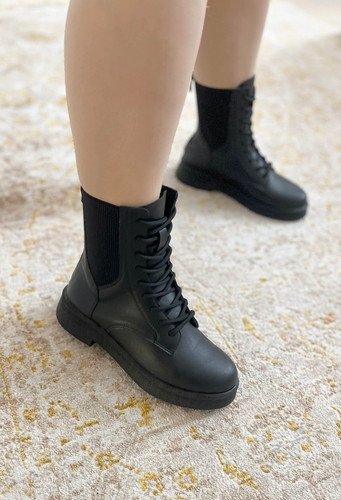 بوت زنانه مدل نُورا رنگ مشکی روی پا، طراحی ساقبلند و چرم نرم، مناسب استایل پاییز و زمستان